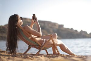 woman using travel apps in spain beach
