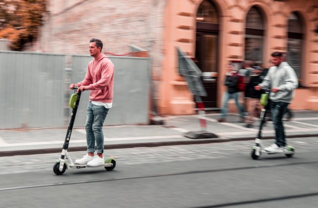 young people driving an electric scooters on the road in Malaga