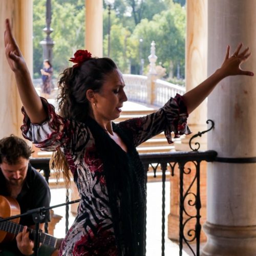 Woman dancing flamenco while a man plays guitar