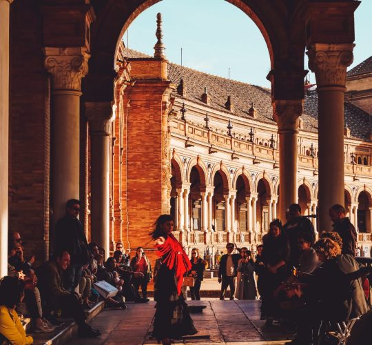 Woman dancing flamenco surrounded by people